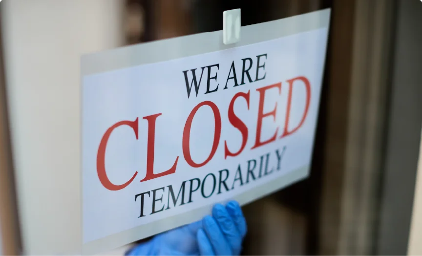 A sign with red text that reads "WE ARE CLOSED TEMPORARILY"