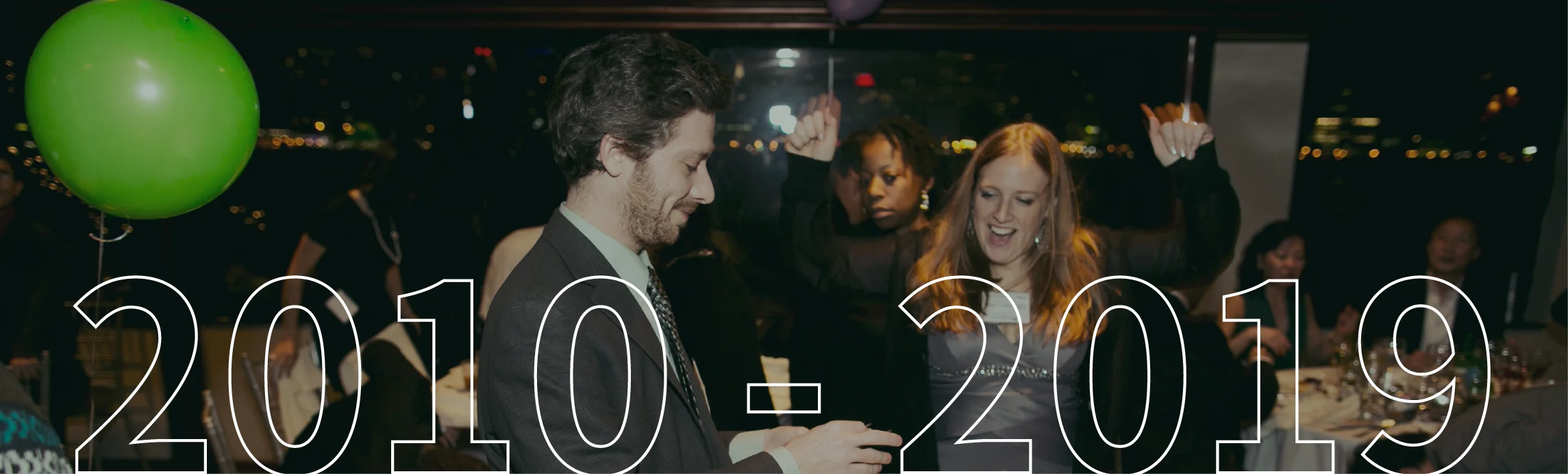People celebrating at a formal evening event with the text "2010 - 2019" overlaid.