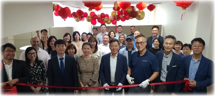 A group of executives participating in a ribbon-cutting ceremony for a new Flushing branch opening.