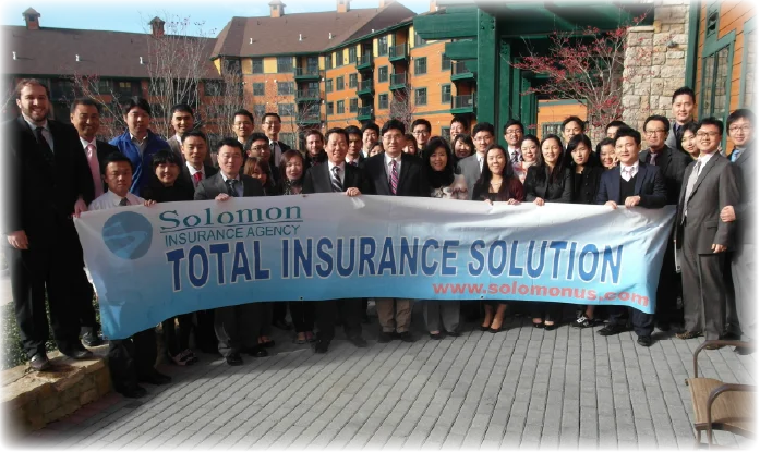 A group of people holding a banner that reads "Total Insurance Solution".