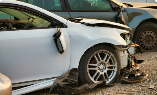 The front-end damage of a white car after a traffic accident.