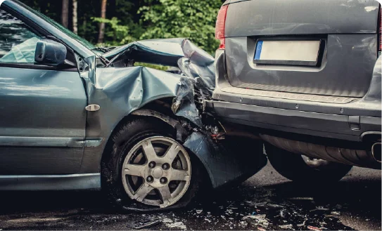 A silver car damaged after a rear-end collision with another vehicle.