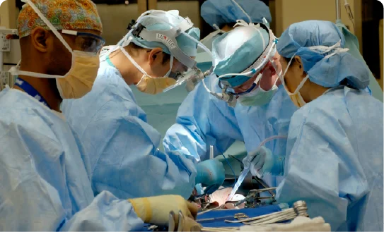 A team of surgeons performing a medical procedure under bright lights.